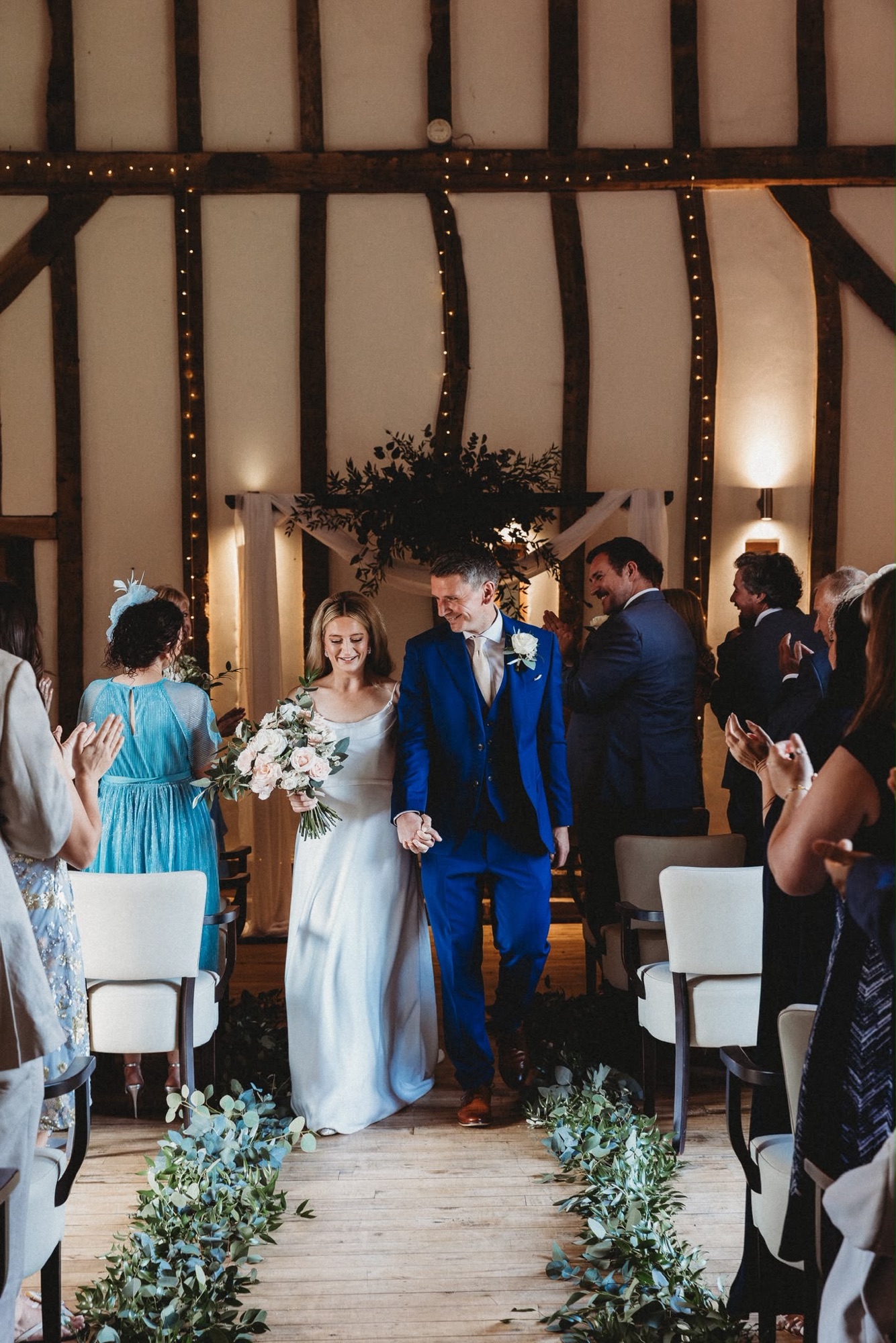 Newlyweds walking back down the aisle in the Crooked Barn